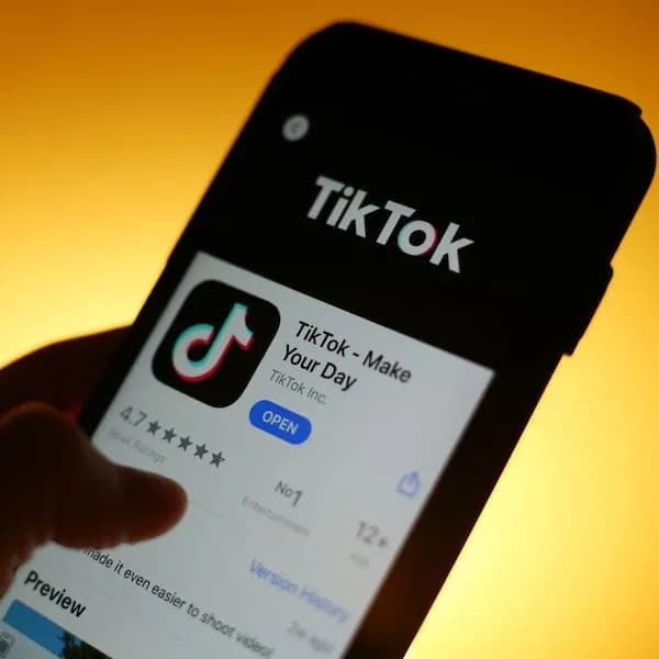 A hand selecting the tiktok app on a phone.